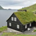 Huis in Bøur, op de achtergrond het karakteristieke eilandje Tindhólmur